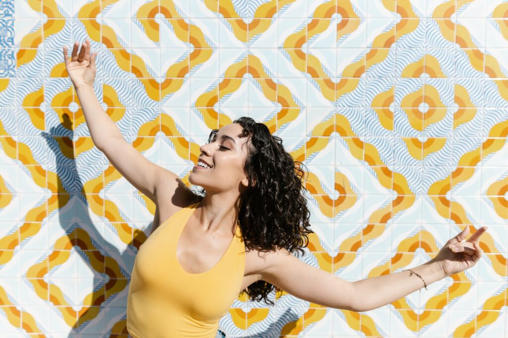a young woman dancing by a tiled wall